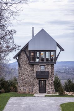 a stone house with two story windows on the top floor and second story above it