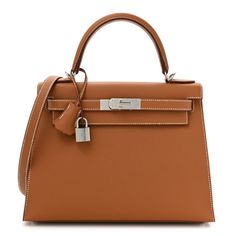 This is an authentic HERMES Epsom Kelly Sellier 28 in Gold. This Hermes classic handbag is beautifully crafted in stamped epsom calfskin leather in brown. A single rolled leather top handle is secured with polished gold plated hardware and an optional leather shoulder strap is included. The traditional gold Kelly turn lock secures the small flap with a padlock. A hanging leather key clochette accessorizes this handbag. The interior features two flat pockets, as well as a zippered pocket, both in Hermes Bag Women, Kelly Sellier, Classic Handbags, Hermes Bags, Leather Key, Leather Top, Top Handle, Calf Skin, Shoulder Strap