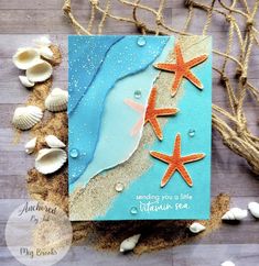 a card with two starfishs on the beach and shells in the sand next to it