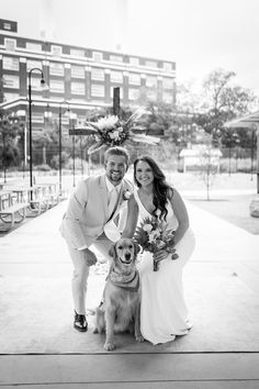 a bride and groom pose with their dog