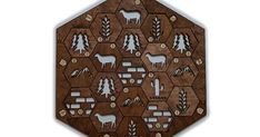 a wooden cutting board with animals and plants on the sides, cut out into hexagonal shapes