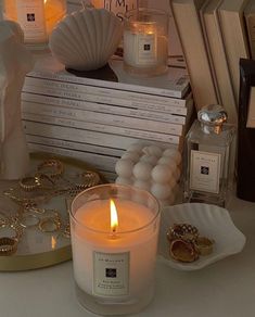 a candle sitting on top of a table next to some books and other items in front of it