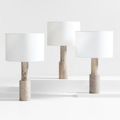 three lamps sitting next to each other on top of a white surface with one lamp turned off