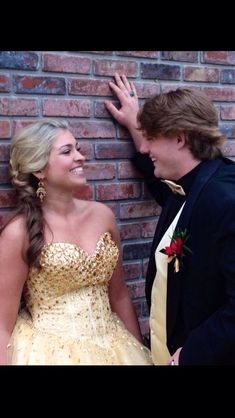 a man in a tuxedo standing next to a woman wearing a gold dress