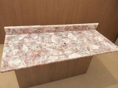 a marble counter top in front of a wooden wall