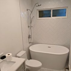 a white bathroom with a tub, toilet and sink