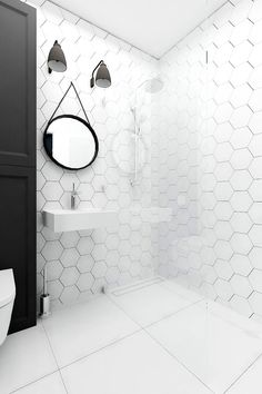 a white tiled bathroom with black and white accessories