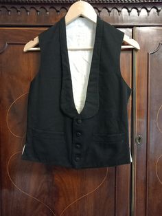 Old Genuine Vintage 1900s Suit Waistcoat Transport yourself back to the elegant days of the late 19th to early 20th centuries with this exquisite Victorian Edwardian waistcoat vest, believed to be from the 1900s to 1910s. With its timeless design and historical significance, this piece is a true vintage gem. This waistcoat features a four-button front, two welt pockets, and a distinctive shawl label, adding to its vintage charm. It's a piece of fashion history that reflects the style and sophist Vintage Formal Vest With Buttons, Fitted Vintage Vest With Buttons, Vintage Fitted Vest With Buttons, Sleeveless Buttoned Vest For Costume, Fitted Daywear Vest With Buttons, Fitted Vest With Buttons For Daywear, Elegant Daywear Vest With Buttons, Black Elegant Vest For Costume, Elegant Black Vest For Costume