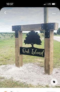 a wooden sign sitting on top of a lush green field