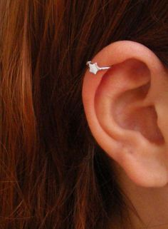 a woman's ear is shown with an origami piece in the middle