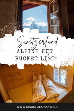 a bed sitting under a window in a bedroom next to a window sill with the words, switzerland alpine hut bucket list