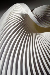 an abstract white sculpture with wavy lines on it