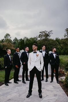 a group of men standing next to each other in tuxedos and bow ties