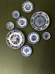 blue and white plates are arranged on a green surface