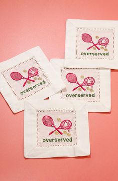 three embroidered tea towels with tennis racquets on them and the words overserved