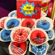 there are many donuts with sprinkles and spiderman decorations on them