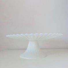 a white cake plate sitting on top of a table