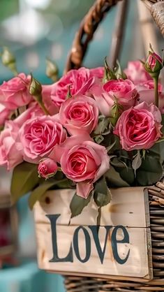 a basket filled with pink roses sitting on top of a table