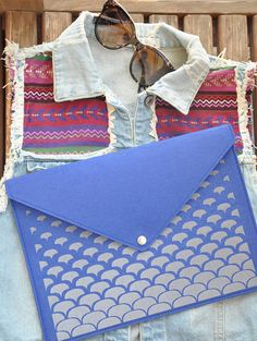 a pair of sunglasses sitting on top of a piece of cloth next to a blue envelope