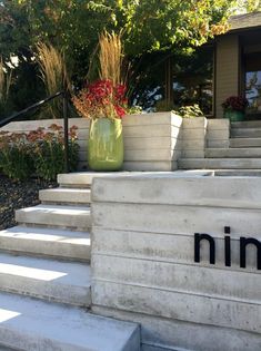 there is a planter sitting on the steps in front of this building that says nim