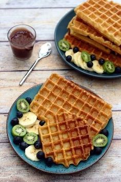 two plates with waffles and fruit on them