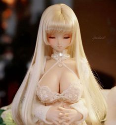 a doll with long blonde hair wearing a white dress and laces on it's chest