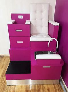 a pink and white chair with drawers on the floor in front of a purple wall