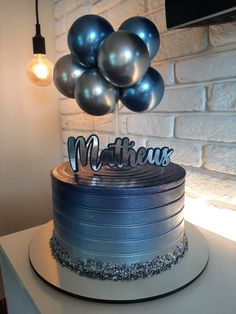 a birthday cake with blue and silver balloons on top that reads, mother's day