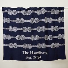 a blue and white towel hanging on a clothes line with the name, the hamilons est 2094 printed on it