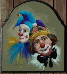 a painting of two clowns on a wooden wall