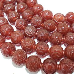 a pile of red beads sitting on top of a white table