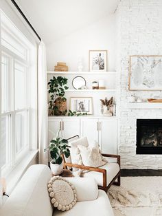 a living room filled with furniture and a fire place next to a white brick wall