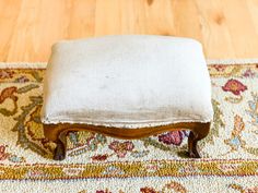 a foot stool sitting on top of a rug