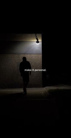 the silhouette of a person standing in front of a wall with words written on it