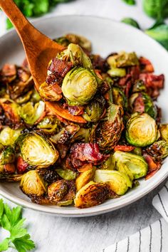 a white bowl filled with brussel sprouts and bacon