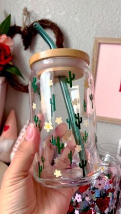 a person holding up a glass jar filled with confetti and strawberries in it