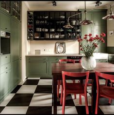 a kitchen with green cabinets and black and white checkered flooring on the floor