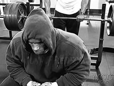 a man squatting down in front of a barbell