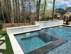 an outdoor swimming pool in the middle of a yard with grass and trees around it