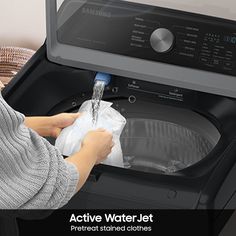 a woman is cleaning the front loader of a washing machine with a cloth in it