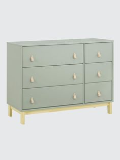 a light green dresser with four drawers and two handles on each drawer, in front of a white background