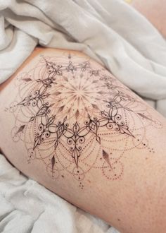 a woman's leg with a tattoo on it that looks like an intricate design