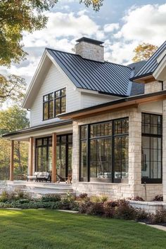 a white house with black windows and a metal roof