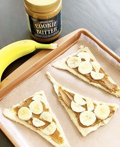 three slices of banana and peanut butter on a tray