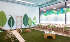 an indoor play area with green grass and trees