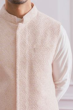 Editor's Note Featuring A Traditional Lucknowi Powder Pink Nehru Jacket With Delicate Thread And Sequence Embroidery And Minimal Details. Perfect For An Outdoor Occcasion. This Comes With A Tonal Plain Ivory Cotton Silk Kurta And Churidaar. Color: Pink Fabric: Cotton And Cotton Silk Care: Dry Clean Only About the Designer Ankit V Kapoor is a clothing brand that amalgamates traditional Indian handicrafts and bespoke tailoring. Inspired by the heritage of India and unified with revolutionary thoug Kurta With Nehru Jacket For Men, Kurta Jackets For Men Wedding, Kurta Jackets For Men, Trending Kurta For Men, Traditional Indian Mens Clothing