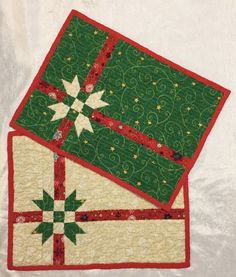 two quilted christmas gift boxes sitting on top of each other