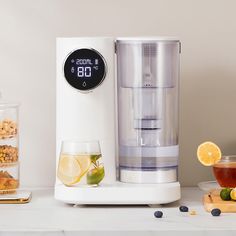 a water dispenser sitting on top of a counter next to a cup of tea