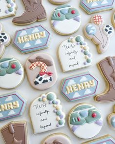 decorated cookies are arranged in the shape of cowboy boots and boots with words on them