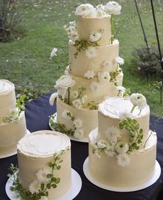 a wedding cake sitting on top of a table covered in white flowers and greenery